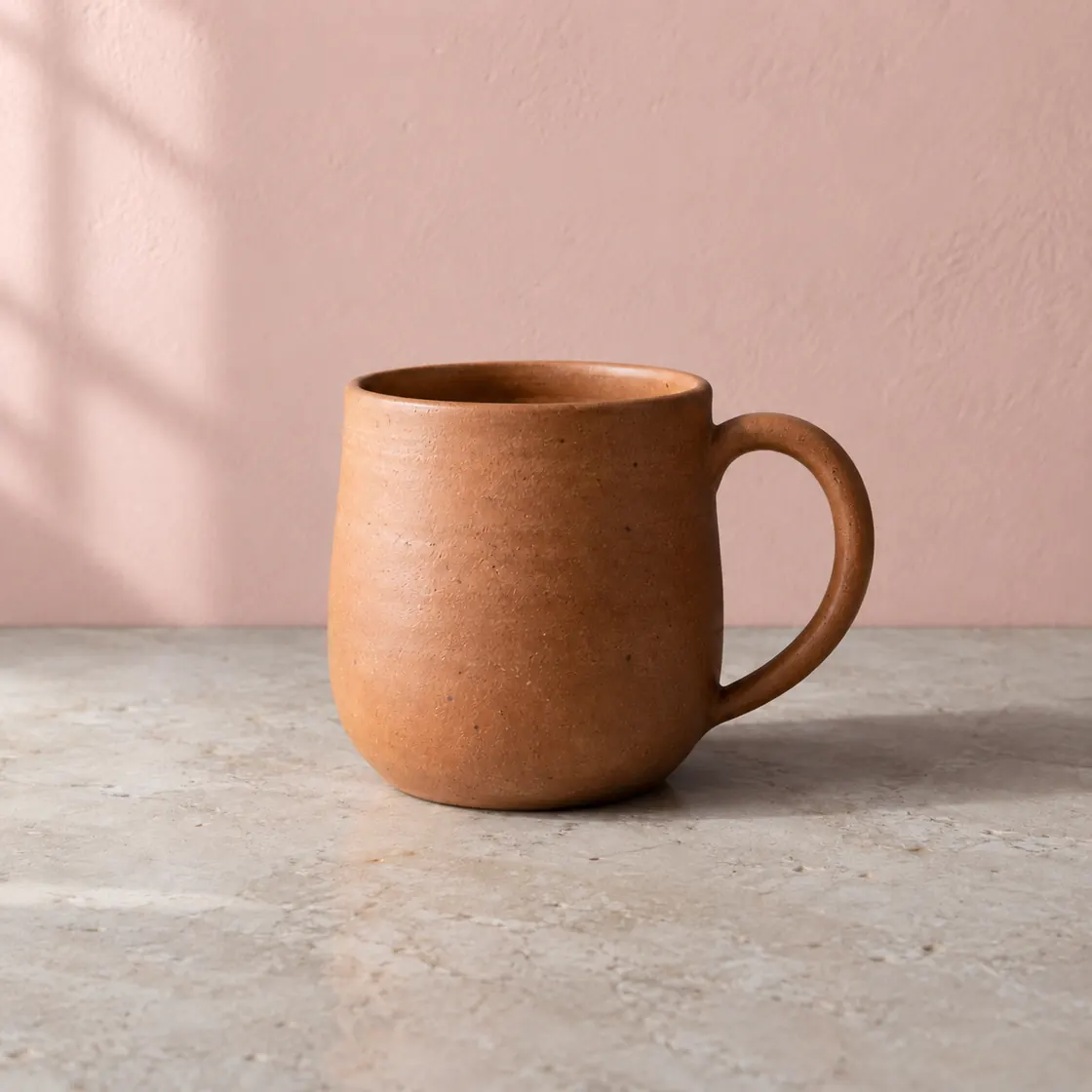 Terracotta mug against a blush-pink wall, an illustrative background edit.
